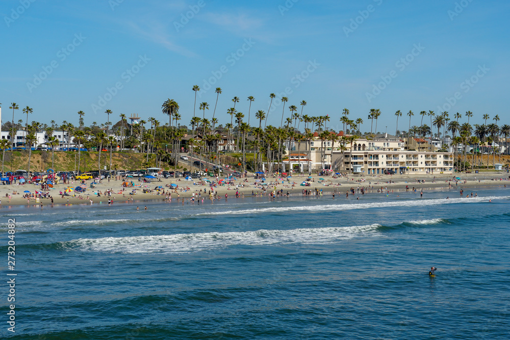 People on the beach enjoying beautiful spring day at Oceanside beach in San Diego, California. 