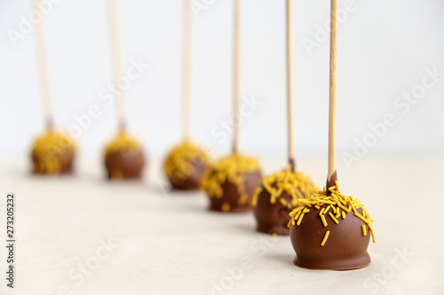 chocolates on wooden sticks close-up stand in a row. Focus in the foreground, background blurred.