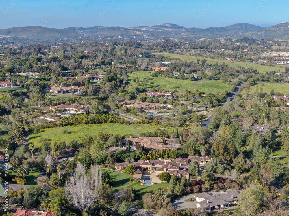 Aerial view of wealthy countryside area with luxury villas with swimming pool, surrounded by forest and mountain valley. Ranch Santa Fe. San Diego, California, USA.