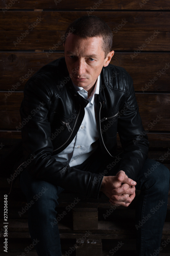 outdoor portrait of a very beautiful serious man, dark hair, posing in classic suit on black background outdoor portrait of a very beautiful serious man, dark hair, posing in classic suit on black background