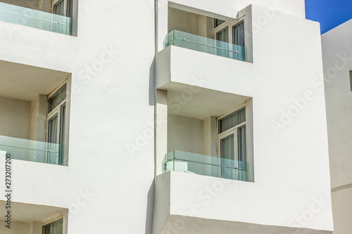 living apartment building outside facade wall with window and balconies in bright sunny light 