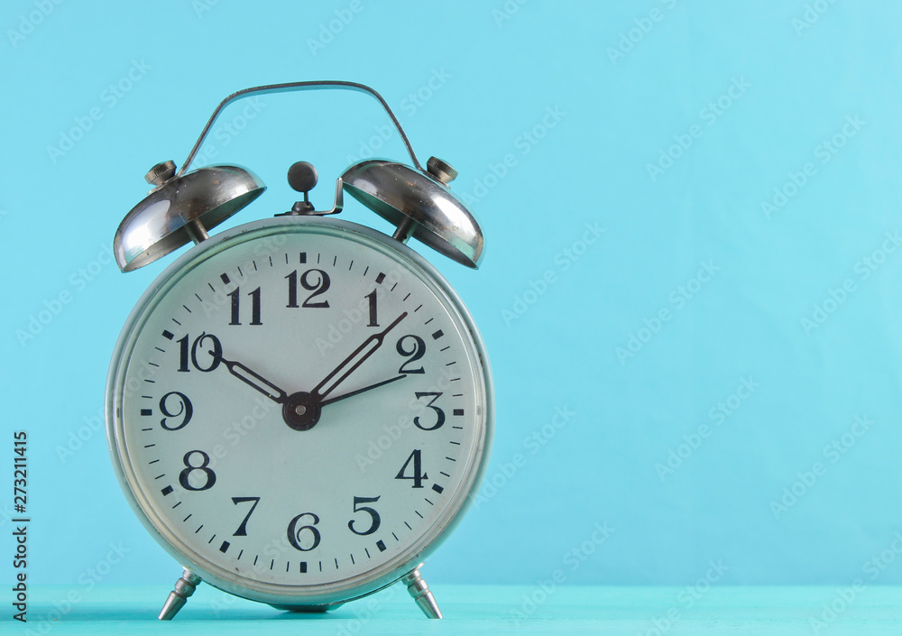 Retro alarm clock closeup on a blue background. Retro alarm clock closeup on a blue background.