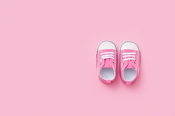 Cute pink baby girl sneakers close up on pink background