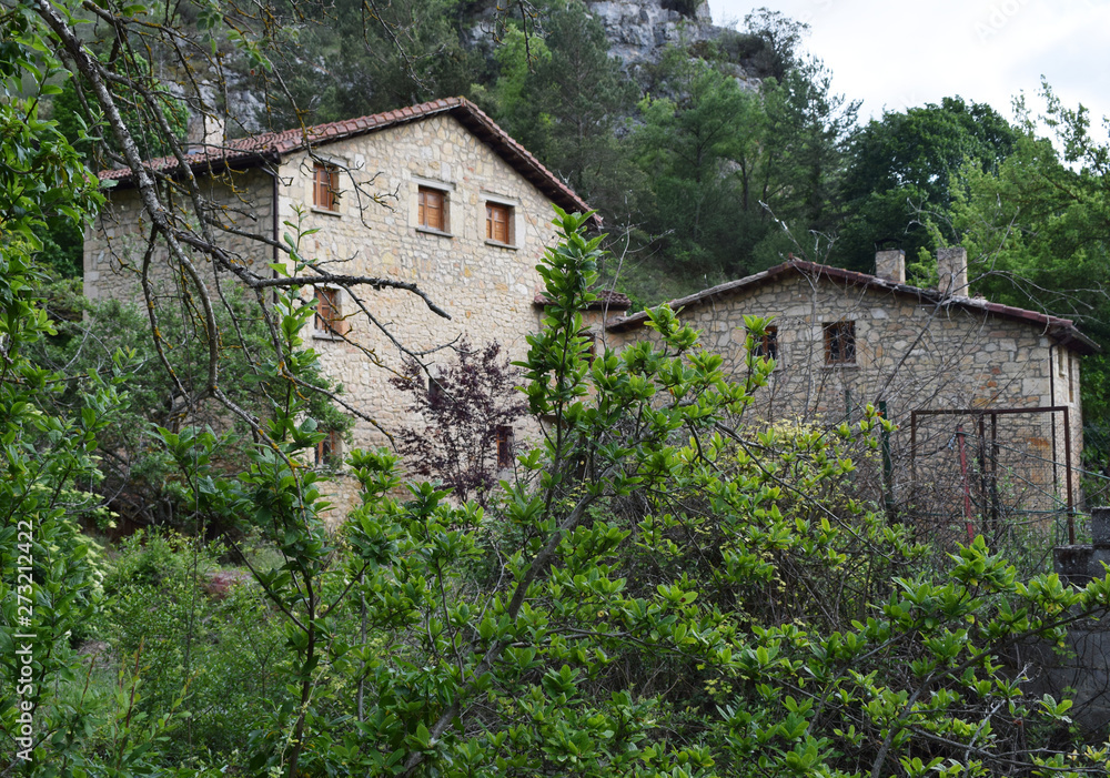 Casas antiguas de piedra entre bosques.