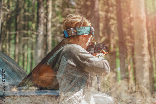 Back view of a boy in smoke, playing laser tag and aiming an optical gun. Toned image on a light background.