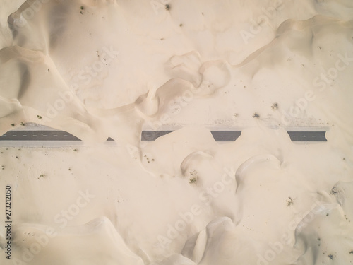 Aerial abstract view of road covered by sand in the desert, Abu Dhabi, UAE. photo