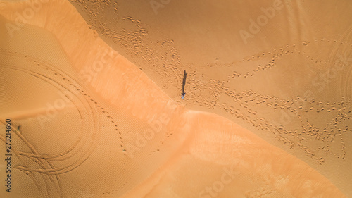 Aerial view of a man walking alone in the dunes of Sharjah desert, U.A.E. photo