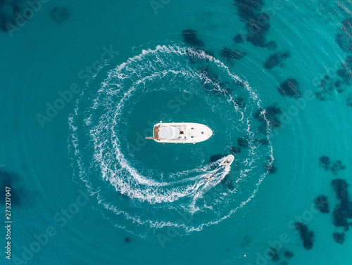 Aerial view of jet ski driving around yacht in the mediterranean sea, Mikonos island, Greece. photo