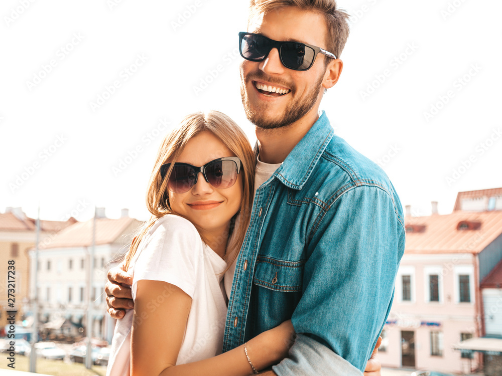 Portrait of smiling beautiful girl and her handsome boyfriend. Woman in casual summer jeans clothes. Happy cheerful family. Female having fun on the street background in sunglasses Portrait of smiling beautiful girl and her handsome boyfriend. Woman in casual summer jeans clothes. Happy cheerful family. Female having fun on the street background in sunglasses
