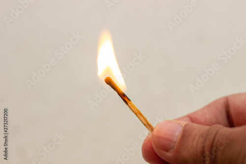 Lit match in hand. A lit match on a white background. Lighted match in hand on white background. Burning match in hand. Burning match on white background