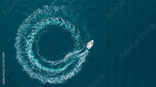 Aerial view of a boat driving in circle in the sea. photo