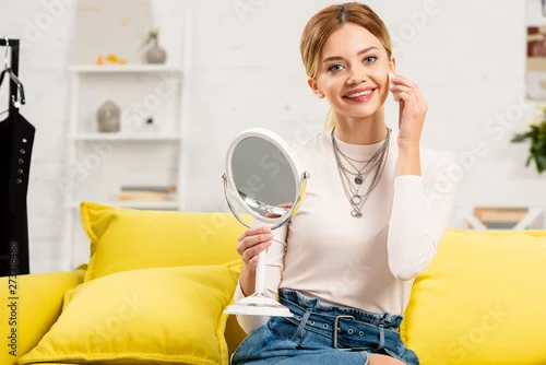 Obraz smiling beauty blogger with mirror using decorative cosmetics in front of video camera