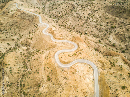 Aerial view of a serpentine empty road in the desertic landscapes of Ethiopia. photo