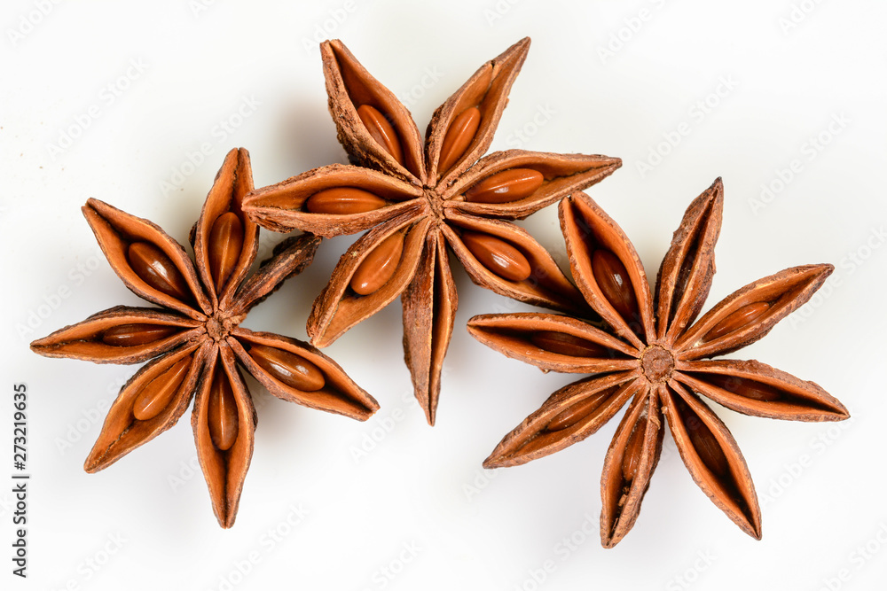 Star anise. Three star anise fruits. Macro close up Isolated on white background with shadow, top view of chinese badiane spice or Illicium verum. Star anise. Three star anise fruits. Macro close up Isolated on white background with shadow, top view of chinese badiane spice or Illicium verum.