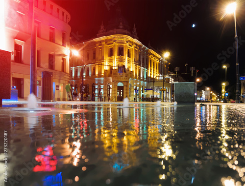 Night illuminated Lublin city in reflection wet center architecture street