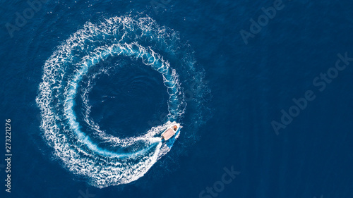 Aerial photography of a boat creating circle with wake in the Ionan sea close to Ithaca island in Greece. photo