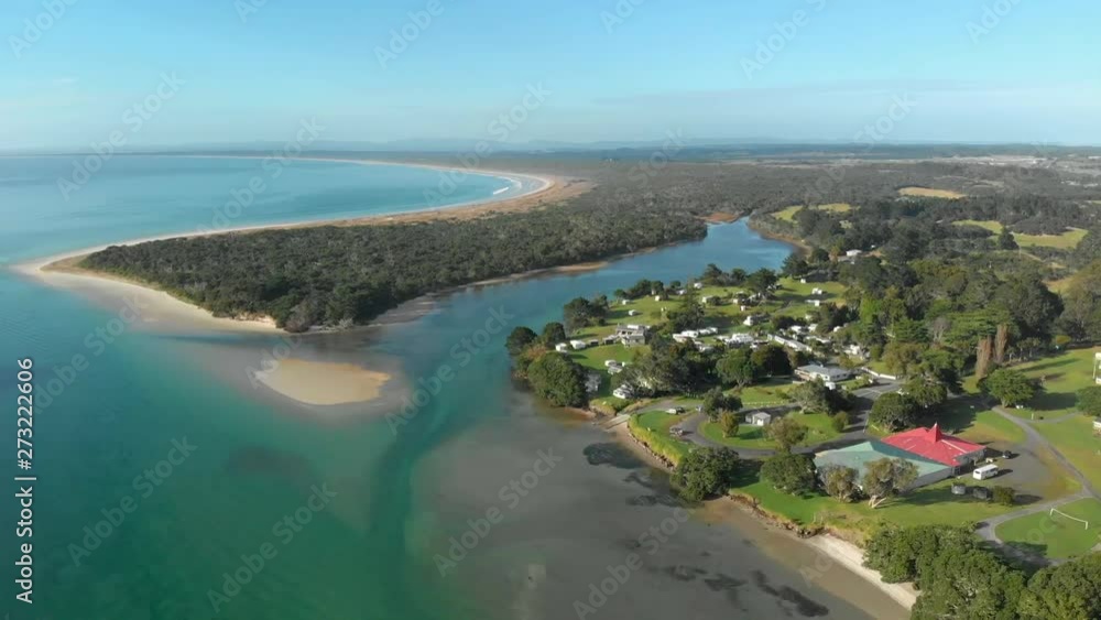 Aerial drone push-in pull-down shot of a small coastal town surrounded by trees, mangroves and beaches Aerial drone push-in pull-down shot of a small coastal town surrounded by trees, mangroves and beaches