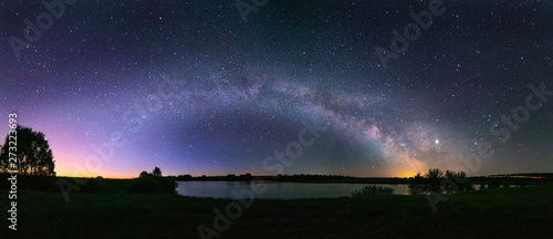 Night panorama of the arch of the Milky Way, above the lake in the northern hemisphere