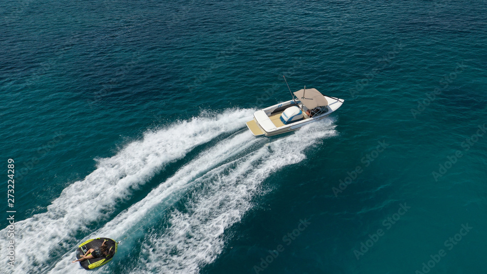 Aerial photo of extreme powerboat donut watersports crusing in high speed in tropical turquoise bay