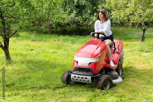 Woman in field garden job driving a lawn mower © OceanProd