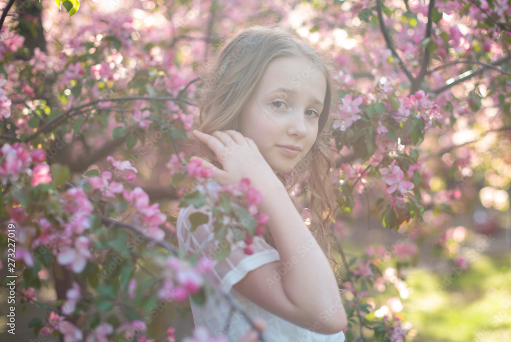 teen girl near the blossoming apple trees in sun rays teen girl near the blossoming apple trees in sun rays