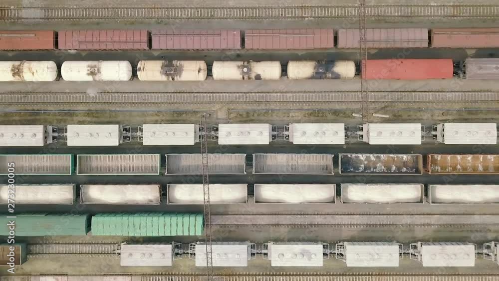 Freight railway cars at the railway station. Aerial view. Tanks and containers with cargo are on the rails on a sunny summer day. Commercial rail transportation Freight railway cars at the railway station. Aerial view. Tanks and containers with cargo are on the rails on a sunny summer day. Commercial rail transportation