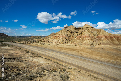 une route dans le désert des Bardenas devant une montagne ocre