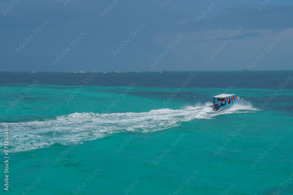 Boat in blue Caribbean sea at Isla Mujeres in Quintana Roo, Mexico Boat in blue Caribbean sea at Isla Mujeres in Quintana Roo, Mexico