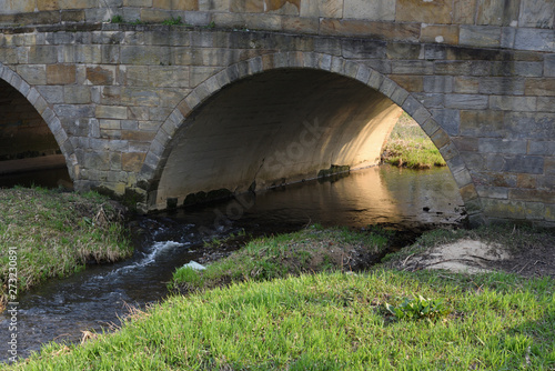 old bridge over the river Mistelbach in Bayreuth in back lit photo