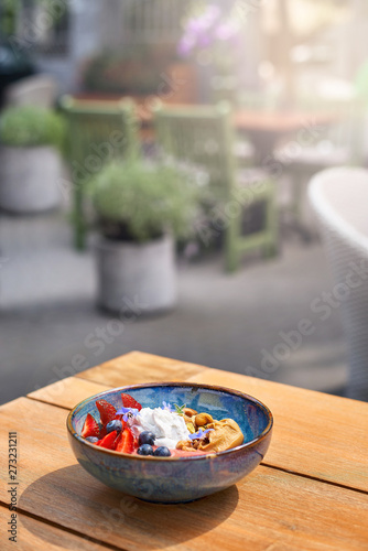 Morning Breakfast in a blue plate on the table. fresh berries Blueberry smoothie breakfast bowls of nuts, seeds and fruit. selective focus.