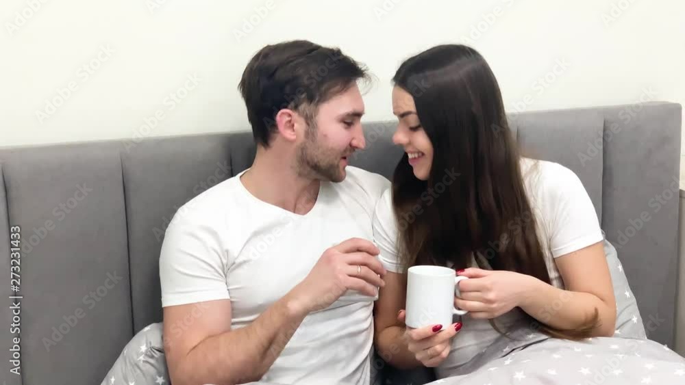 Beautiful morning. Young couple drinking coffee in bed Beautiful morning. Young couple drinking coffee in bed