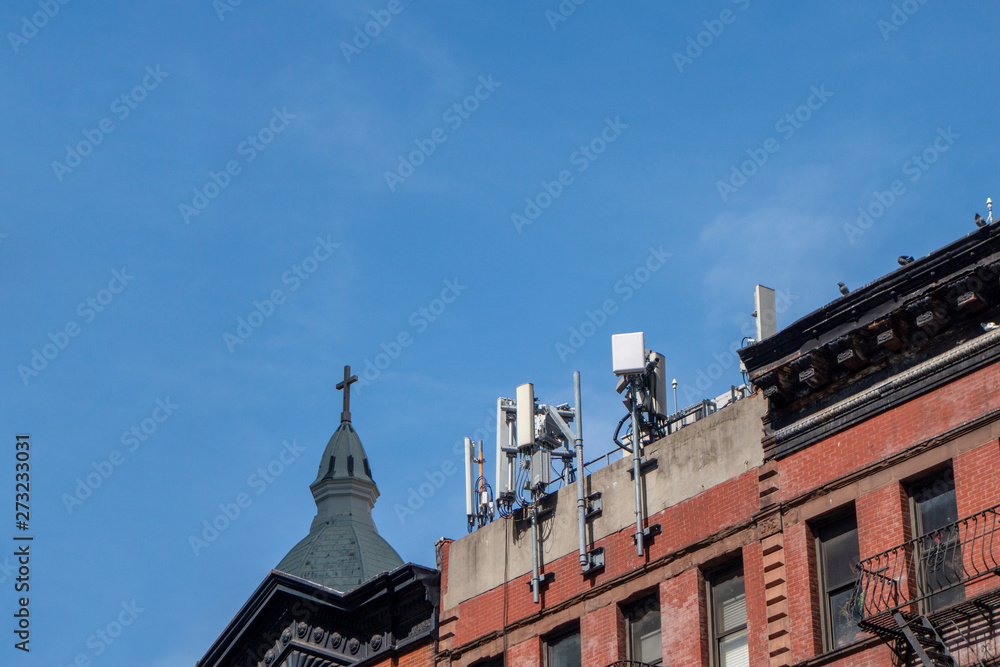 New York building with cellular towers on a their rooftop on a bright sunny day