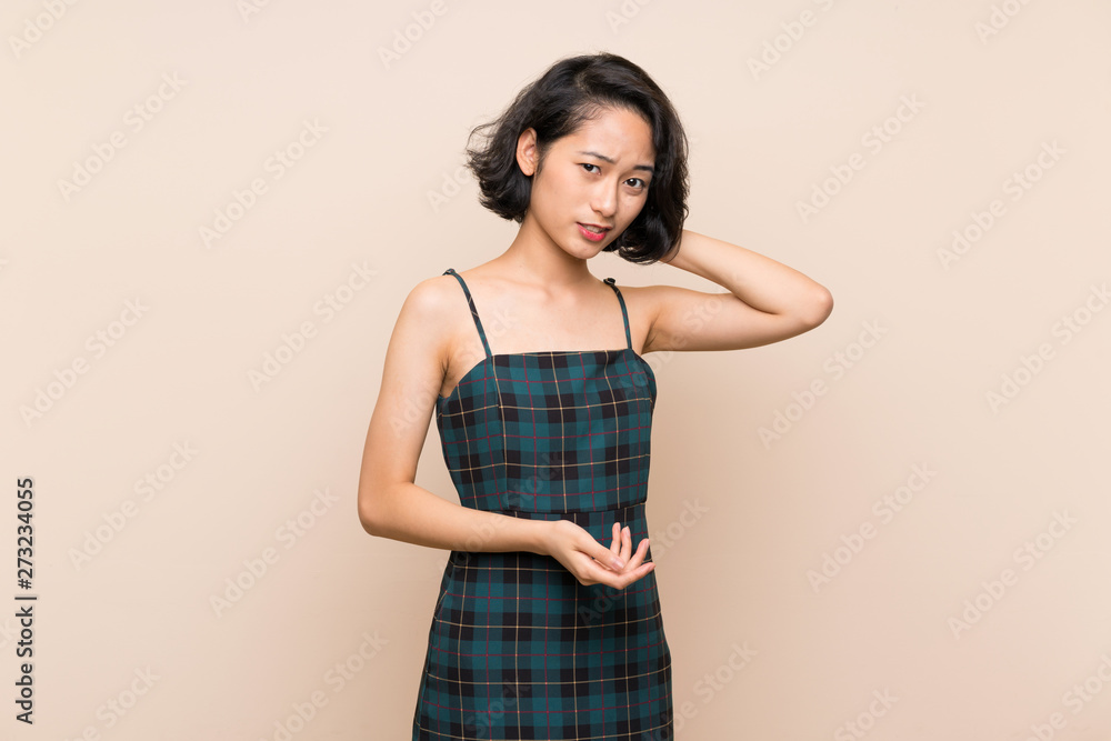 Obraz premium Asian young woman over isolated yellow wall having doubts
