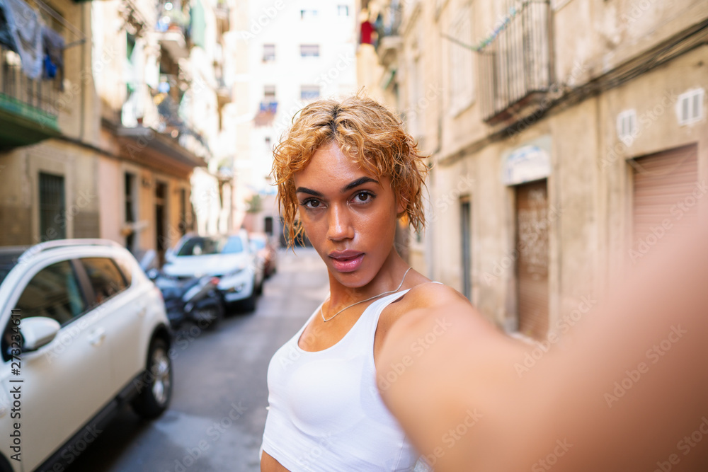 Beautiful transsexual woman posing in the city and doing selfie. Modern city Beautiful transsexual woman posing in the city and doing selfie. Modern city