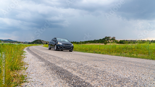 Car on the way among green fields in Phrygia Valley Natural Park (Frig Vadisi Tabiat Parki), Ihsaniye, Afyonkarahisar/Turkey.