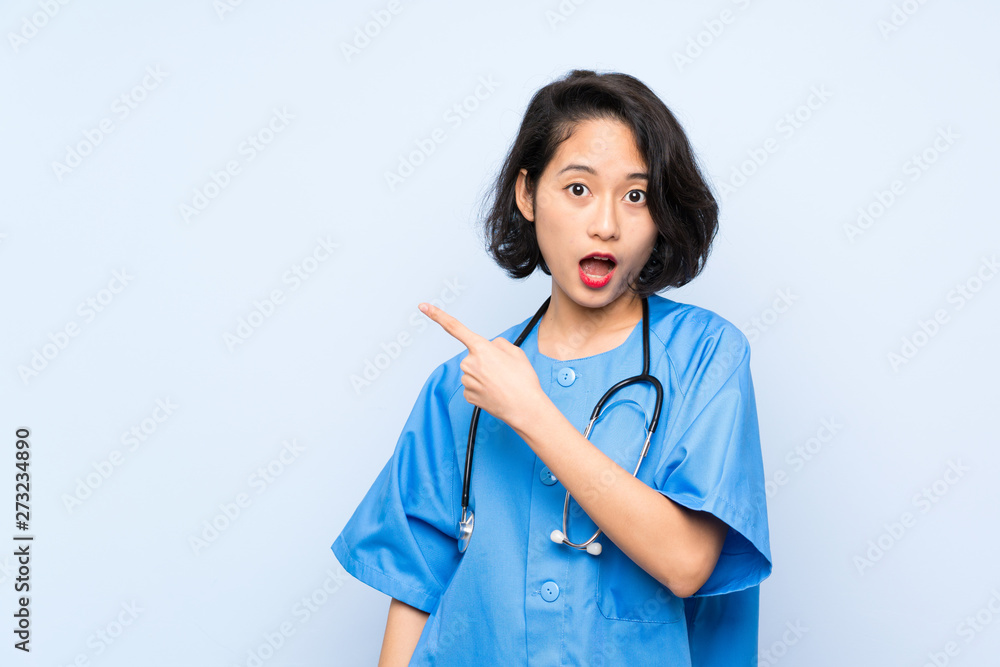 Surgeon doctor woman surprised and pointing side Surgeon doctor woman surprised and pointing side