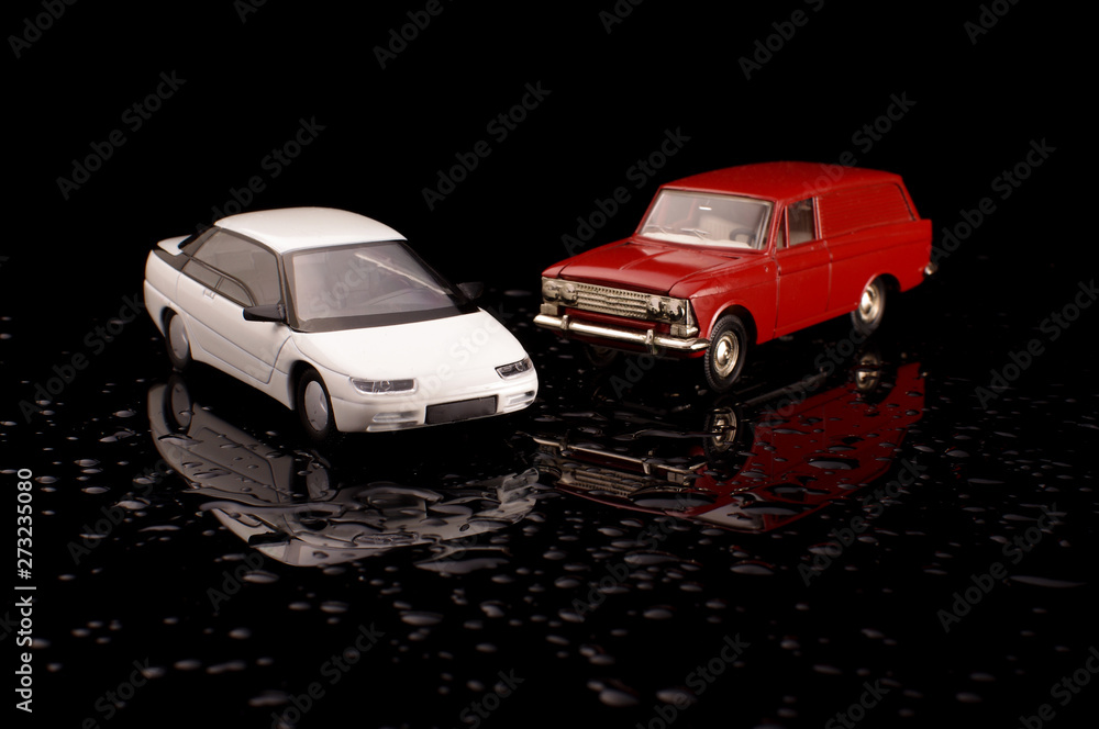 Vintage die-cast plastic and metal model cars on the black reflective background