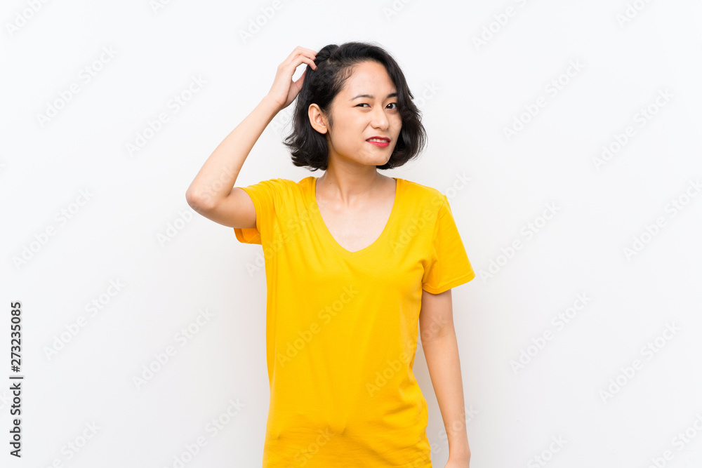 Asian young woman over isolated white background having doubts while scratching head Asian young woman over isolated white background having doubts while scratching head