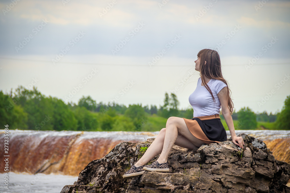 The girl at the waterfall. Young beautiful girl on a little waterfall. Little waterfall.