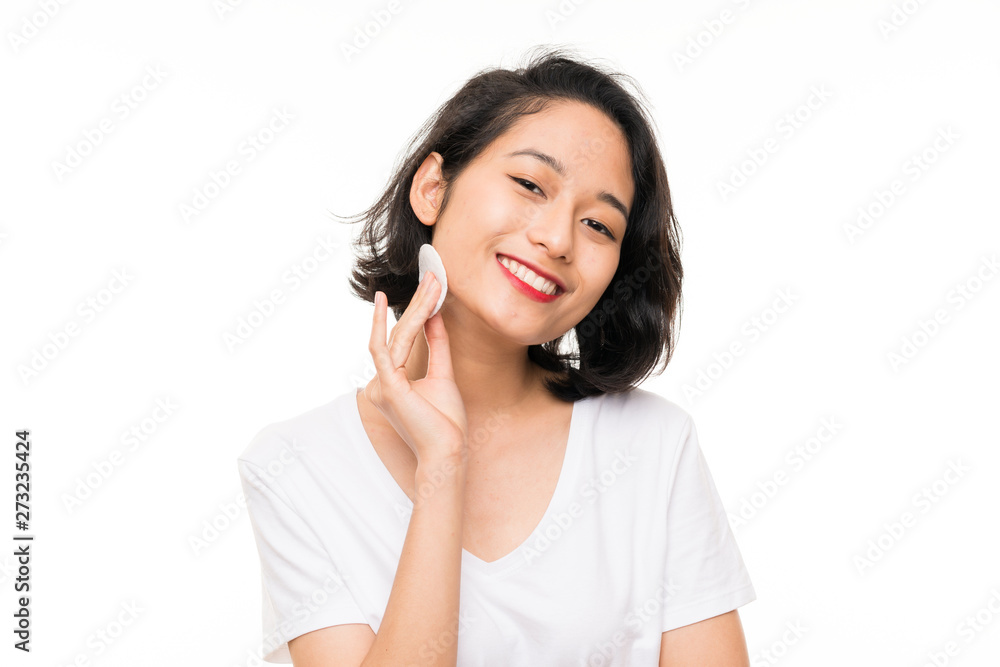 Asian young woman removing makeup from her face with cotton pad Asian young woman removing makeup from her face with cotton pad