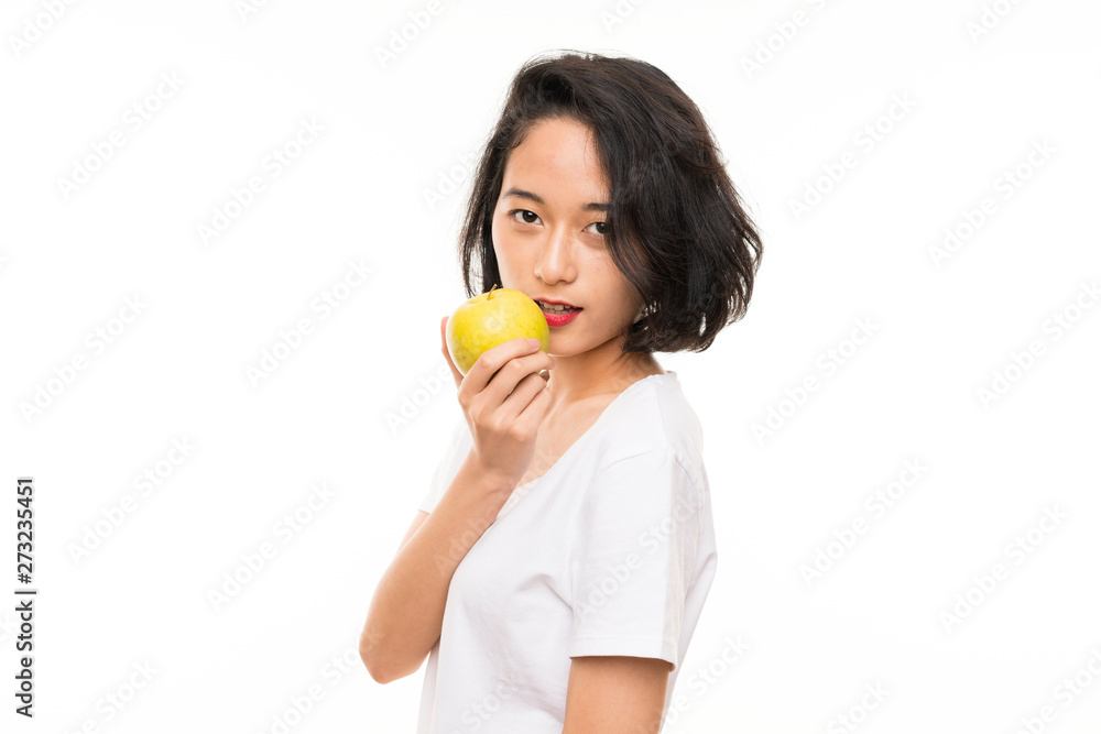 Asian young woman over isolated background with an apple Asian young woman over isolated background with an apple