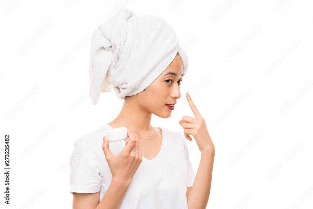 Asian young woman over isolated background with moisturizer Asian young woman over isolated background with moisturizer