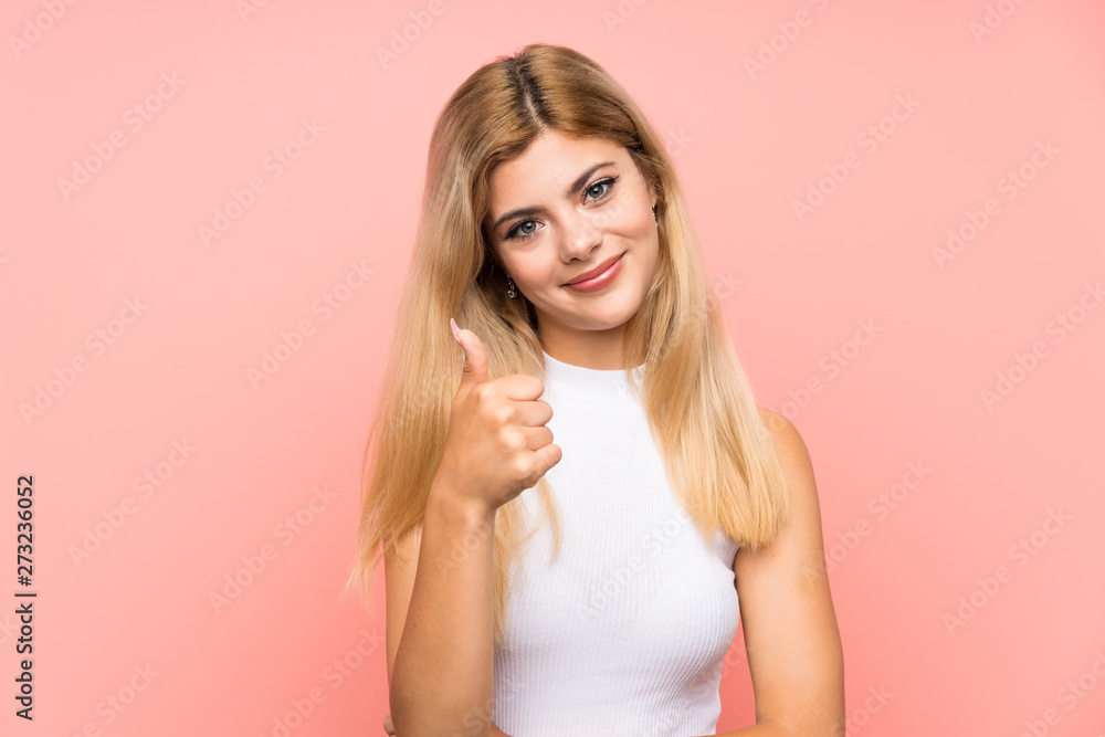 Teenager girl over isolated pink background giving a thumbs up gesture Teenager girl over isolated pink background giving a thumbs up gesture