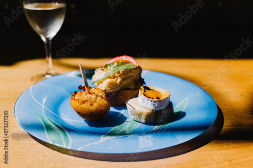 Selection of appetizers, pinxtos, from a bar in San Sebastian, Spain with a glass of hard cider photo