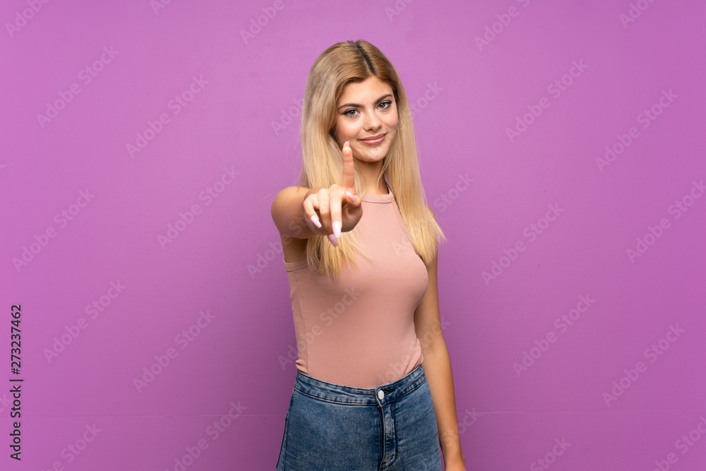 Teenager girl over isolated purple background showing and lifting a finger Teenager girl over isolated purple background showing and lifting a finger