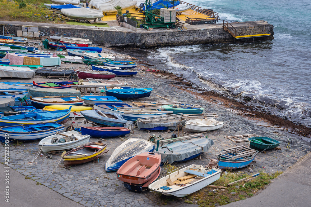 Small fishing boats in port of Aci Castello town on Sicily Island, Italy