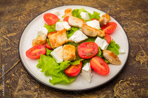 Warm salad with chicken, cherry tomatoes and soft cheese cheese. dressing with olive oil. Dietary meal