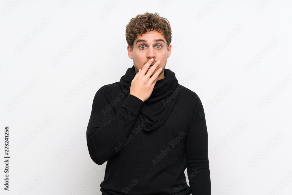 Blonde man over isolated white wall surprised and shocked while looking right Blonde man over isolated white wall surprised and shocked while looking right