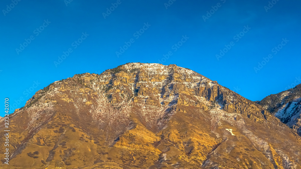 Panorama frame Towering mountain with a residential area near the base against deep blue sky