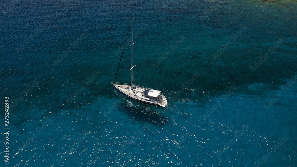 Aerial view of small islet of Ydrousa with turquoise and sapphire clear waters and only one mile distance from coast in Voula, Athens riviera, Attica, Greece